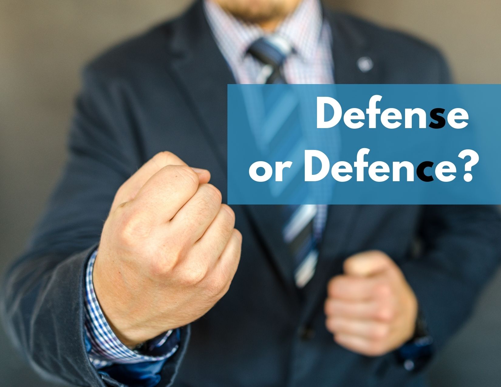 A man with his arms up in defence with the words "Defense or Defence?