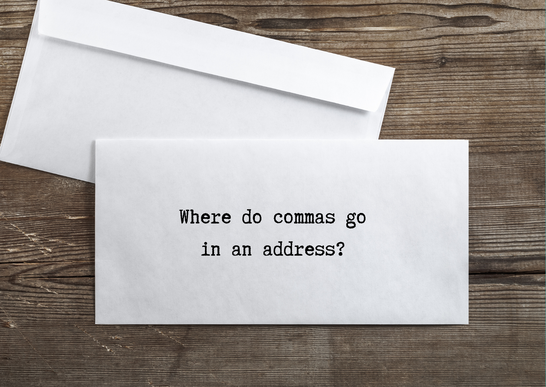 Address punctuation: A picture of two envelopes on a wooden table. The text "does punctuation go inside parentheses" is written in the space where the address should be written in order to signify