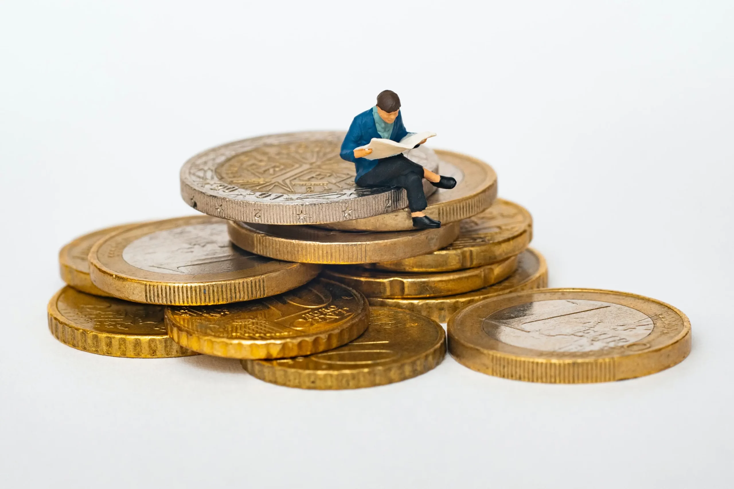 Picture of a man reading while sitting atop of large coins
